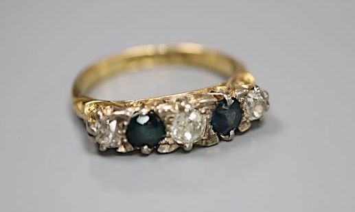 An early 20th century 18ct gold three stone diamond and two stone sapphire set half hoop ring, size K, gross 3.6 grams.
